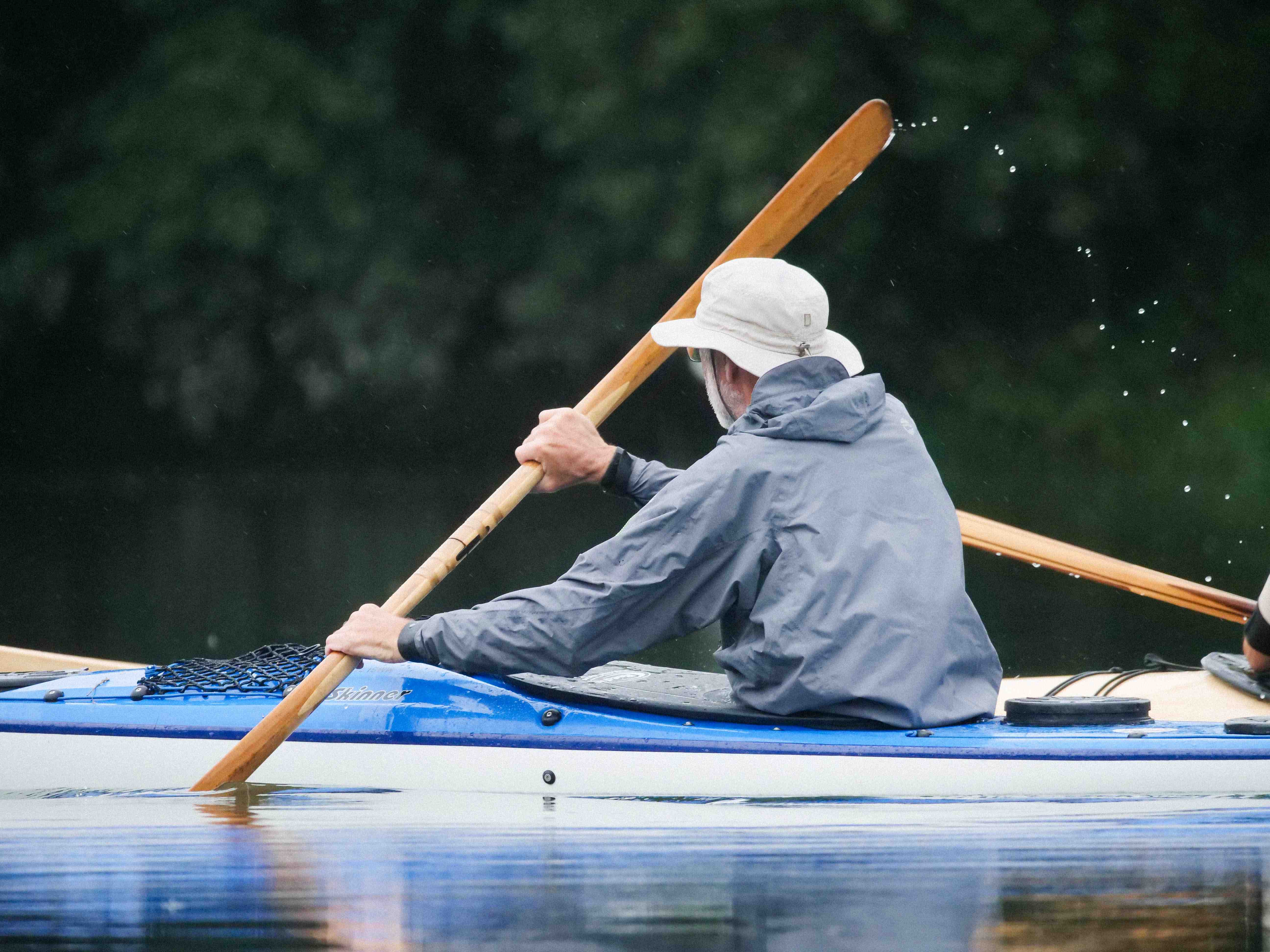 Nahaufnahme von Heinrich, der mit seinem Seekajak und einem Holz-Paddel auf dem Bodensee trainiert