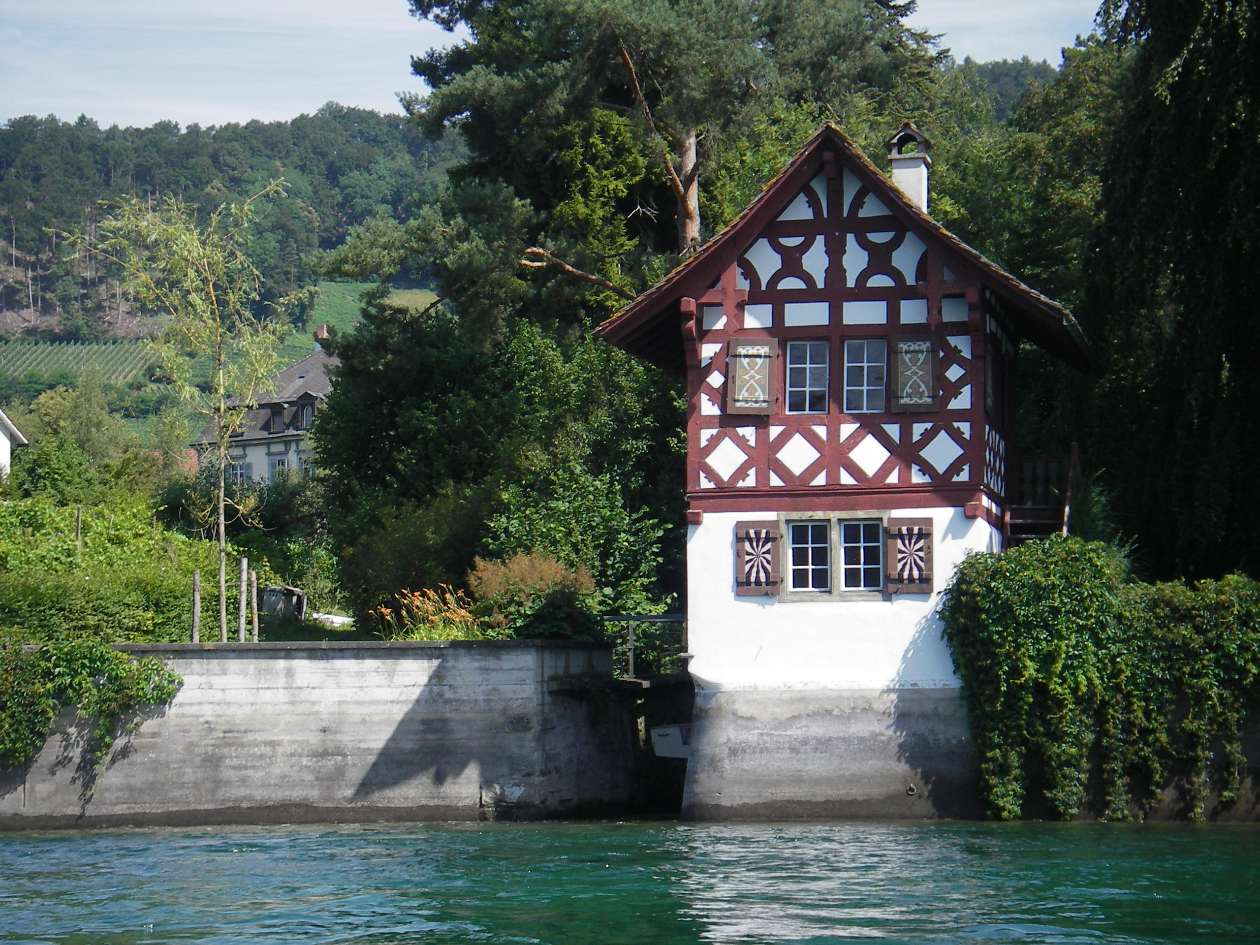 Ein kleines Fachwerkhaus - mehr hoch als breit - zäumt das Hochrhein-Ufer